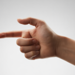 Close-up of a hand with a finger bent and appearing stiff, representing trigger finger