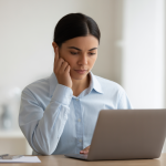Person taking an online certification exam on a laptop, representing secure and trustworthy remote proctoring.