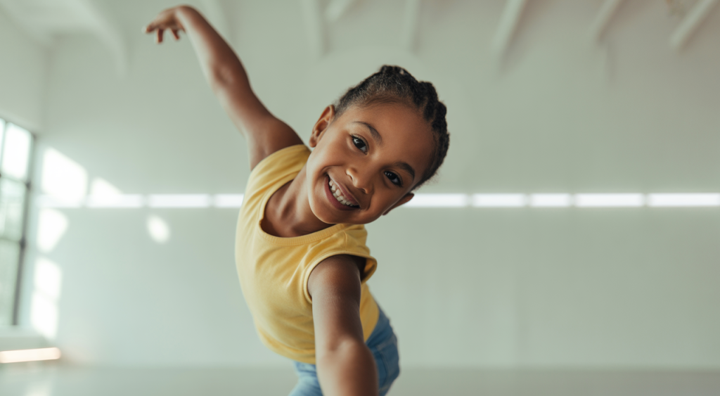 A child with diverse abilities joyfully dancing in an adaptive dance class, illustrating growth and self-expression.