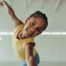 A child with diverse abilities joyfully dancing in an adaptive dance class, illustrating growth and self-expression.